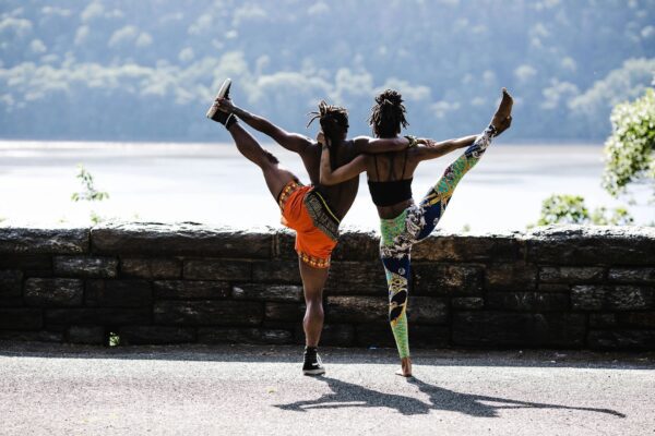 Two people doing different poses on a street.